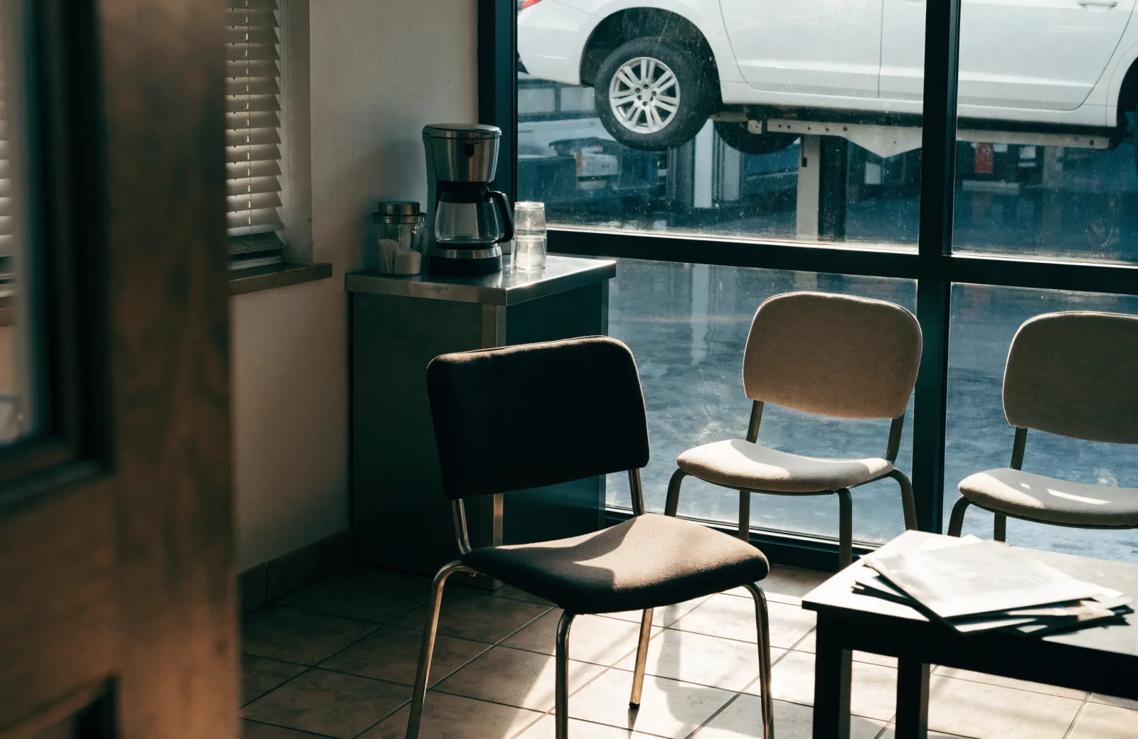 Customer waiting area of a local auto shop with a view into the service bay